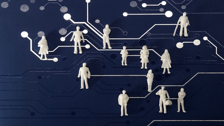 White humanoid figures laid out on a board of circuits all connected, representing cybersecurity career paths