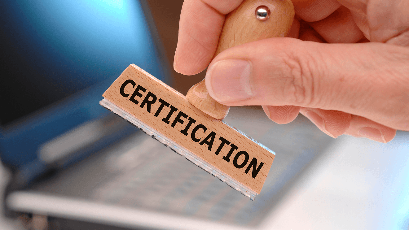 certification stamp in foreground with laptop in background