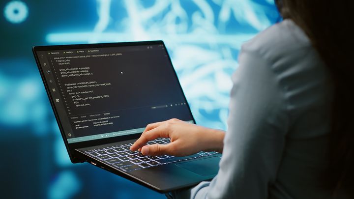  Close up shot of IT expert using AI system and laptop